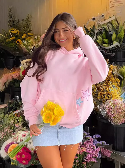 Woman wearing pink fashion hoodies with pocket for women holding yellow flowers standing in flower shop