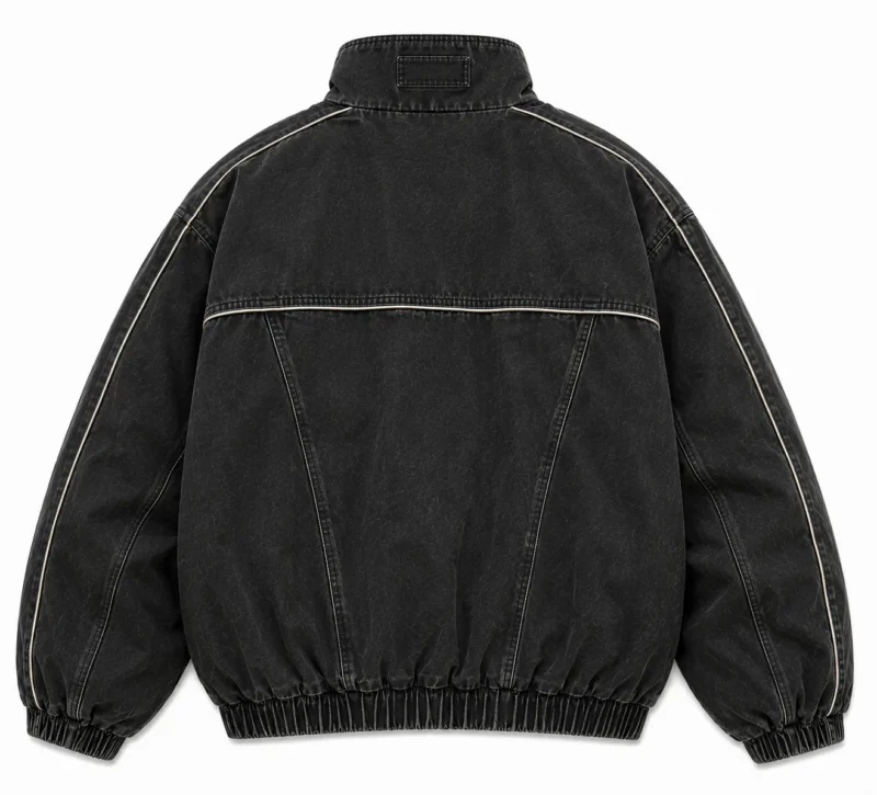 bomber-jacket-vintage-back Back view of a vintage bomber jacket in washed black denim with a structured stand collar, contrast piping, long sleeves and elastic waistband for a classic utility-inspired look.