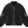 custom-jean-jacket-front Custom jean jacket in black washed denim featuring a full front zipper, pointed collar, ribbed cuffs and hem, embroidered graphic detailing and decorative sleeve patches.
