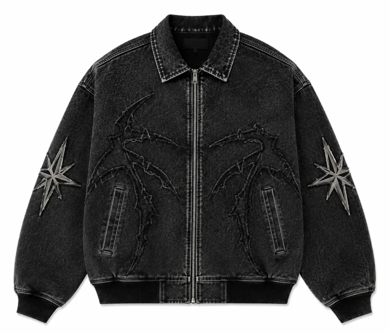 custom-jean-jacket-front Custom jean jacket in black washed denim featuring a full front zipper, pointed collar, ribbed cuffs and hem, embroidered graphic detailing and decorative sleeve patches.