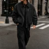 mens-retro-bomber-jacket-streetwear Man wearing a retro bomber jacket made from washed black denim, featuring a full zipper, multiple secure pockets, ribbed cuffs and waistband, and a vintage streetwear-inspired design.
